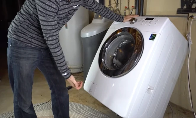 Washer not draining — technician diagnosing drain pump on front-load washing machine